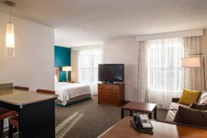 a hotel room with a bed and a flat screen tv at Residence Inn Arundel Mills BWI Airport in Hanover