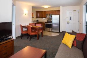a living room with a couch and a kitchen at Residence Inn Arundel Mills BWI Airport in Hanover