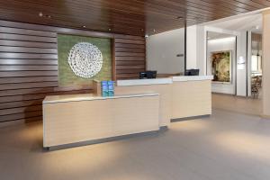 an office lobby with a reception desk and wooden walls at Fairfield Inn & Suites by Marriott Fort Collins South in Fort Collins