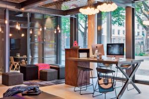 an office with a desk with a computer on it at MOXY Frankfurt East in Frankfurt
