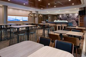 um restaurante com mesas e cadeiras e um bar em SpringHill Suites by Marriott Kansas City Northeast em Kansas City