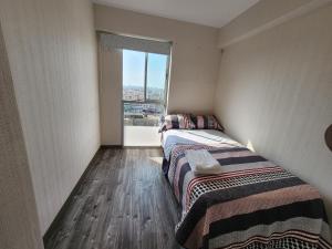 2 camas en una habitación con ventana en Dpto acogedor con terraza privada en Lima