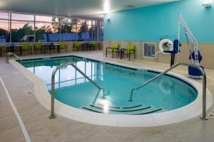 a pool in a hotel room with tables and chairs at SpringHill Suites by Marriott Kansas City Northeast in Kansas City