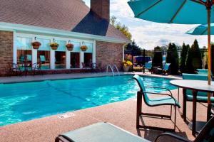 a swimming pool with a table and an umbrella at Residence Inn Boston North Shore/Danvers in Danvers