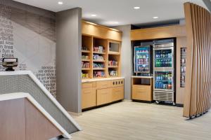 a kitchen with a refrigerator and a staircase at SpringHill Suites by Marriott Ames in Ames
