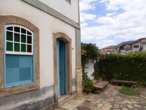 un bâtiment avec une porte bleue et un banc dans l'établissement Casa de João, à Ouro Preto