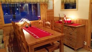 a dining room with a wooden table with candles on it at Petäjäkylä in Kuusamo