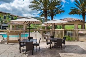 a patio with tables and umbrellas next to a pool at Courtyard by Marriott San Luis Obispo in San Luis Obispo