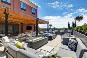 un patio avec des canapés et des tables et un bâtiment dans l'établissement Courtyard by Marriott Manhattan Aggieville, à Manhattan