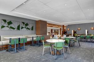 a restaurant with tables and chairs in a room at Courtyard by Marriott Manhattan Aggieville in Manhattan