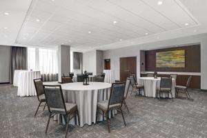 a conference room with tables and chairs and a screen at Courtyard by Marriott Manhattan Aggieville in Manhattan