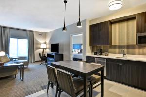 a kitchen and living room with a table and chairs at Residence Inn by Marriott Cleveland Airport/Middleburg Heights in Middleburg Heights