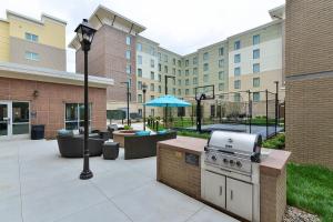 eine Außenterrasse mit einem Grill und einen Innenhof mit Gebäuden in der Unterkunft Residence Inn by Marriott Des Moines Downtown in Des Moines