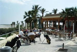 a group of people sitting at tables near the beach at Modern Villa Frontline Golf in Algorfa