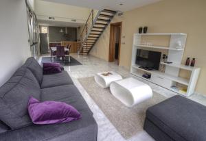 a living room with a gray couch and purple pillows at Modern Villa Frontline Golf in Algorfa