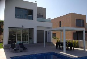 a house with a patio with a table and chairs at Modern Villa Frontline Golf in Algorfa