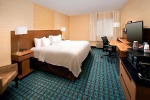 a hotel room with a bed and a desk and a television at Fairfield Inn & Suites by Marriott Albany East Greenbush in East Greenbush