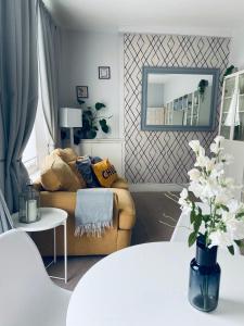 ein Wohnzimmer mit einem Sofa und einem Spiegel in der Unterkunft London Oval Apartment in London