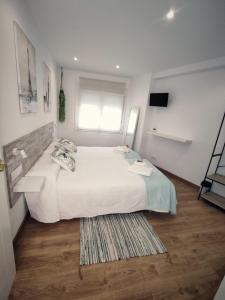 1 dormitorio con 1 cama blanca grande y 1 alfombra en Gallaecia, en Arzúa
