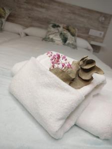 una pila de toallas y flores en una cama en Gallaecia, en Arzúa