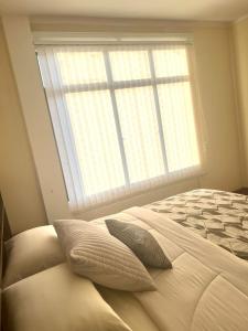 a bedroom with a bed with a large window at Departamento de Patricia in Sucre