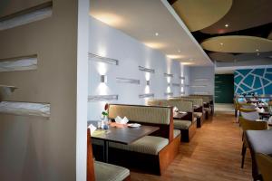 une salle à manger avec des tables et des chaises dans l'établissement Protea Hotel by Marriott Lusaka Cairo Road, à Lusaka