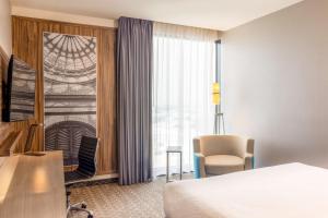 a hotel room with a bed and a chair and a window at Courtyard by Marriott Mexico City Vallejo in Mexico City