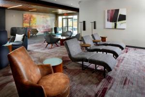 - une salle d'attente avec des canapés, des chaises et une table dans l'établissement Courtyard by Marriott Houston Intercontinental Airport, à Houston