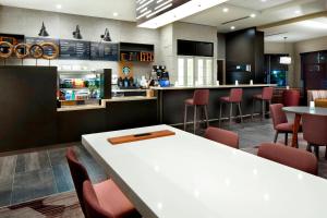 um restaurante com um bar com mesas e cadeiras em Courtyard by Marriott Houston Intercontinental Airport em Houston