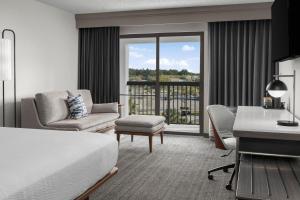 Habitación de hotel con cama, escritorio y silla en Courtyard Jacksonville Butler Boulevard en Jacksonville