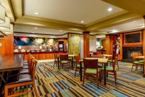皮奧里亞的住宿－Fairfield by Marriott Peoria East，一间带桌椅的餐厅和一间酒吧