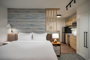 a bedroom with a large white bed and a kitchen at TownePlace Suites by Marriott Las Vegas North I-15 in Las Vegas