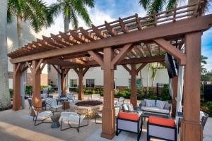 eine hölzerne Pergola mit Stühlen und einer Feuerstelle in der Unterkunft Courtyard by Marriott Sarasota at University Town Center in Sarasota