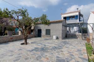 a building with a tree in front of it at Samian Thalia Apartment in Pagóndas