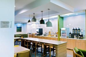a restaurant with tables and chairs and a kitchen at Fairfield Inn Hays in Hays
