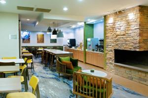 a restaurant with tables and chairs and a fireplace at AmericInn by Wyndham Hays in Hays