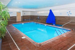 a large swimming pool with blue water in a building at Fairfield Inn Hays in Hays