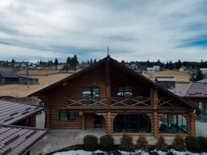 a large wooden house with snow on the ground at Cold River Resort in Dorna Arini