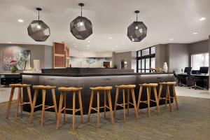 a lobby with a bar with stools around it at SpringHill Suites Dulles Airport in Sterling