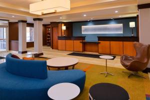 a lobby with a blue couch and a stage at Fairfield Inn and Suites by Marriott Fort Wayne in Fort Wayne