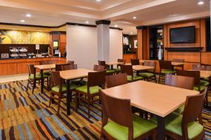 un restaurant avec des tables en bois et des chaises vertes dans l'établissement Fairfield Inn and Suites by Marriott Fort Wayne, à Fort Wayne