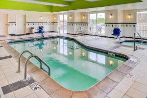 une grande piscine intérieure dans un hôtel doté de plafonds verts dans l'établissement Fairfield Inn and Suites by Marriott Fort Wayne, à Fort Wayne