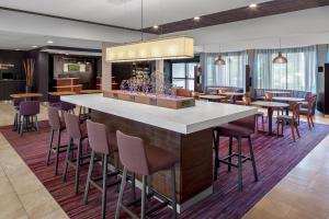 a lobby with a bar with chairs and tables at Courtyard by Marriott Pittsburgh Airport in Coraopolis