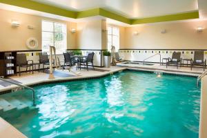 Fairfield Inn and Suites Columbus Polaris في كولومبوس: مسبح في غرفة الفندق مع الكراسي والطاولات