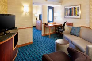 a living room with a couch and a television in a hotel room at Fairfield Inn and Suites Columbus Polaris in Columbus