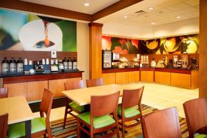 a restaurant with a table and chairs and a bar at Fairfield Inn and Suites Columbus Polaris in Columbus