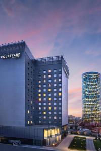 a rendering of a court yard hotel at dusk at Courtyard by Marriott Bucharest Floreasca in Bucharest