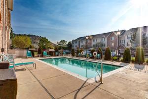 a swimming pool with chairs and a building at TownePlace Suites Colorado Springs in Colorado Springs