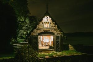 a small building with a clock on the top of it at The Boathouse at Old Court in Strangford