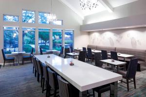 un comedor con mesas, sillas y ventanas en Residence Inn Denver Highlands Ranch, en Highlands Ranch